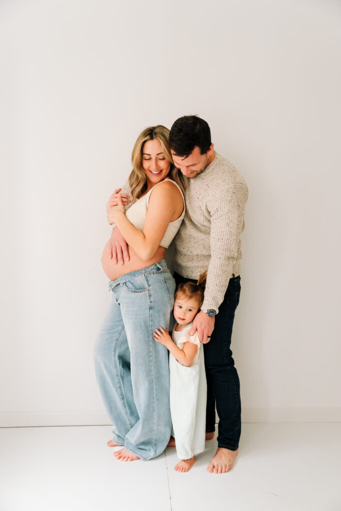 Family maternity session in a neutral studio setting with soft tones and intimate posing in Toledo, Ohio. What to wear to your family photos